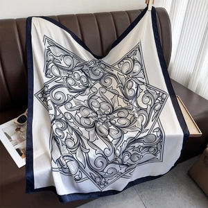 Elegant vintage floral satin square scarf with navy border draped on a sofa