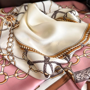 Detailed view of satin square scarf featuring vintage chain and floral horse bridle patterns