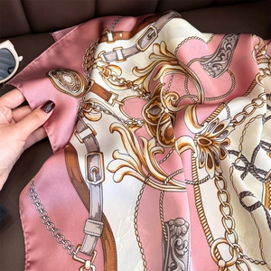 Baroque chain print silk satin square scarf held on premium brown leather background