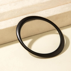 Close-up of minimalist black matte acrylic bracelet with unique geometric tapered design
