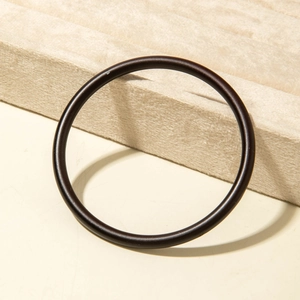 Detail view of dark brown acrylic resin bangle on a beige velvet jewelry display holder