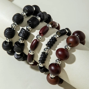 Detail of beaded bracelet set with natural dark wood grains and silver metal accents