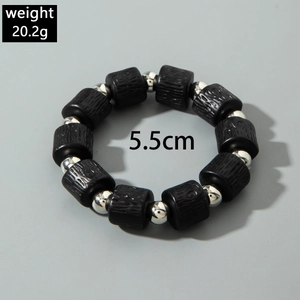 Detail of beaded bracelet showing black wood texture beads and silver metal accents