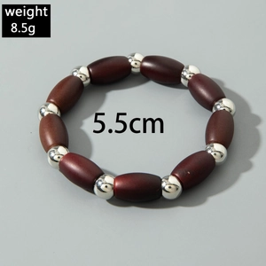 Detailed shot of elastic beaded bracelet with brown wood barrel beads and silver spacers
