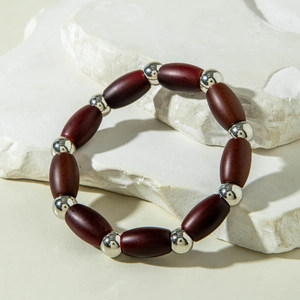 Close-up of beaded stretch bracelet with dark mahogany wood beads and silver metal accents