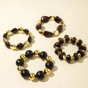 Detailed view of four bohemian elastic beaded bracelets with acrylic and gold accents