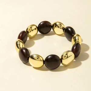 Detail of beaded stretch bracelet with alternating gold and brown acrylic oval beads