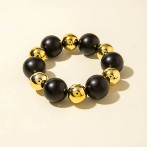 Detailed view of elastic bracelet with matte black and polished gold acrylic beads