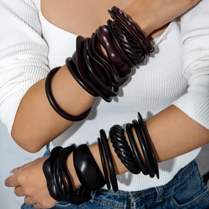 Set of chunky acrylic bangles in dark brown and black featuring geometric bohemian designs