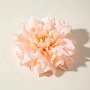 Détail d'une pince à cheveux pivoine en tissu rose avec pétales et étamines jaunes