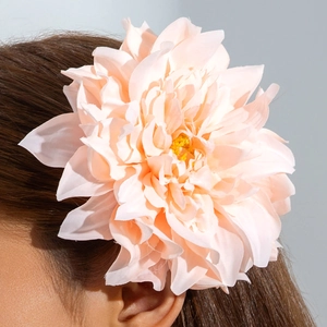 Gros plan d'une grande pince à cheveux pivoine en tissu pêche portée sur les cheveux
