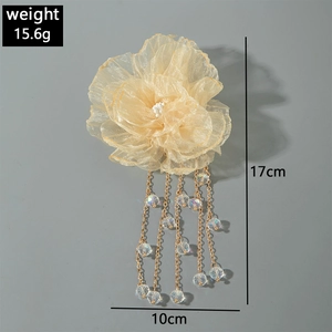 Vue détaillée d'une pince à cheveux fleur en organza jaune avec franges en perles dorées