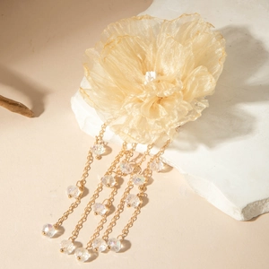 Détail de pince à cheveux pivoine en organza champagne avec perles et franges