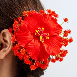 Détail d'une pince à cheveux hibiscus rouge avec étamines jaunes et accents floraux