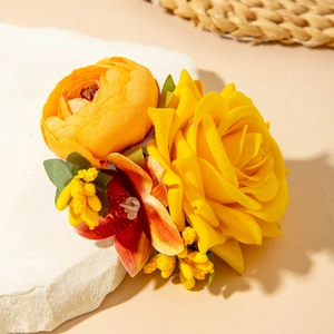 Détail d'une pince à cheveux fleurs en tissu avec rose jaune et orchidée orange vibrante
