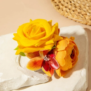 Détail d'une pince à cheveux en tissu avec pivoine et orchidée sur surface en marbre