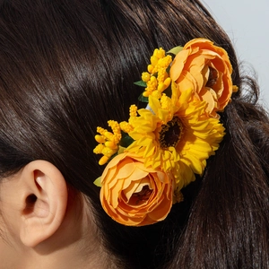 Detail of bohemian sunflower hair comb with yellow silk flowers on long brown hair