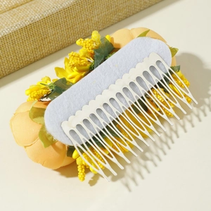 Macro detail of the handmade yellow floral hair comb back with metal teeth and felt