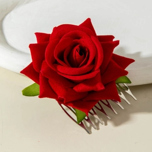 Detail of red velvet rose hair comb with green leaves on a silver metal base