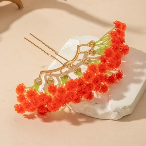 Close-up of bohemian orange floral hair comb with golden U-shaped pins on white stone