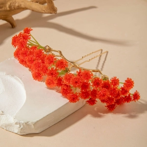 Detailed view of orange bohemian floral hair comb on golden wavy prongs and stone base