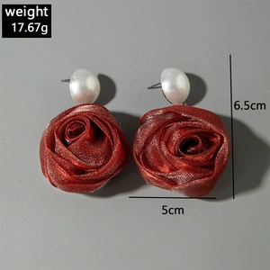 Détail de boucles d'oreilles rose en tissu rouge foncé avec perles et mesure de 6,5 cm