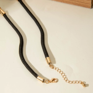 Detail of black woven cord necklace with adjustable gold lobster clasp and extension chain