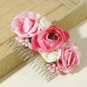 Detail of bohemian hair comb featuring silk roses, pink berries, and silver metal prongs