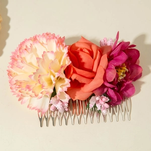 Detail of floral hair comb featuring artificial pink carnations and red roses with silver teeth