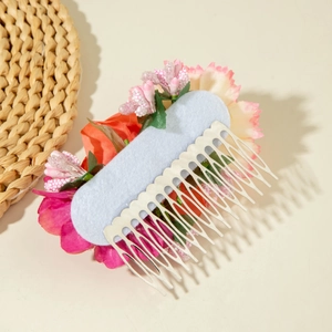 Close-up of bohemian silk flower hair comb with pink petals and metallic comb base