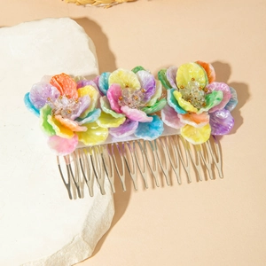 Detailed view of colorful resin flowers and crystal beads on a silver metal hair comb