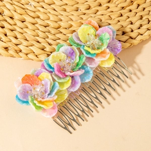 Detail of bohemian floral hair comb with colorful resin flowers and metal teeth