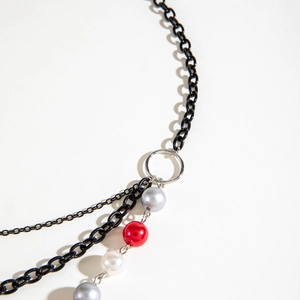 Detailed close-up of multilayer beaded necklace with black chains and colored beads
