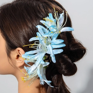 Gros plan du peigne à cheveux fleur bleu clair avec pétales en soie et détails fins
