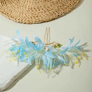 Détail d'un peigne à cheveux fleur en tissu bleu avec des épingles dorées en U