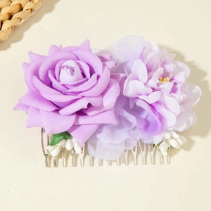 Détail de fleurs en tissu violet et perles blanches sur un peigne à cheveux en métal argenté