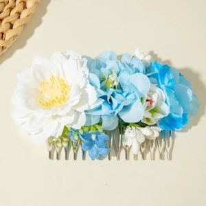 Détail d'un peigne à cheveux avec fleurs 3D en tissu bleu et blanc pour coiffures de vacances