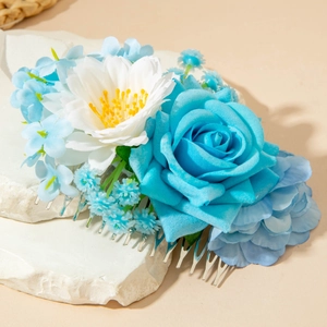 Détail d'un peigne à cheveux avec rose bleue et marguerite pour coiffures de mariée