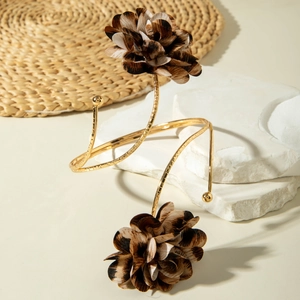 Detailansicht eines goldenen Spiral-Armreifs mit Akzenten aus Leoparden-Stoffblumen