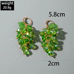 Detail view of grape bead earrings with green crystal clusters and leaf accents