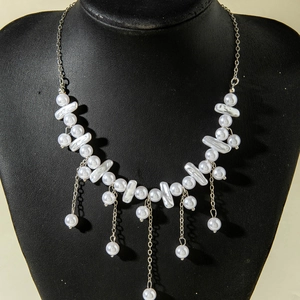 Elegant multi-layer baroque pearl necklace with silver chain tassels on a display stand