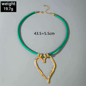 Detail of golden heart pendant with hammered texture and green cord, 43.5+5.5cm length