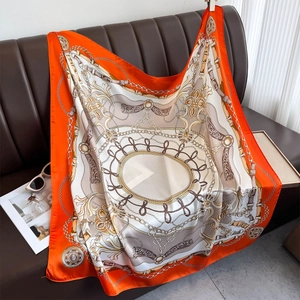 Detailed texture of satin square scarf with vintage chain print on leather background