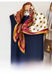 Detail of silk scarf with paisley and polka dot print tied on a navy dress