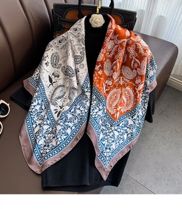 Detailed close-up of paisley and floral patterns on a large square silk scarf