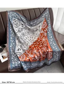 Detail view of 90x90cm paisley silk scarf with orange and blue floral pattern details