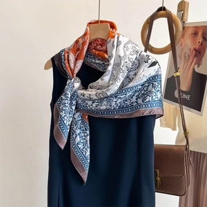 Vintage paisley print silk scarf in navy and orange styled on a blue dress with accessories