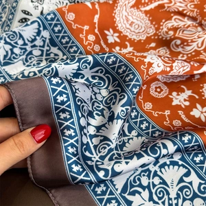 Close-up of silky paisley scarf with orange and navy blue patchwork contrast