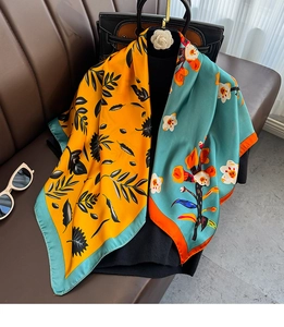 Detailed texture of dual-pattern satin silk square scarf with floral and leaf prints