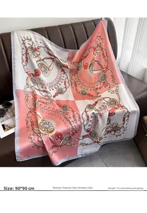 Detail of 90x90cm satin silk scarf featuring gold chain patterns on a luxury sofa